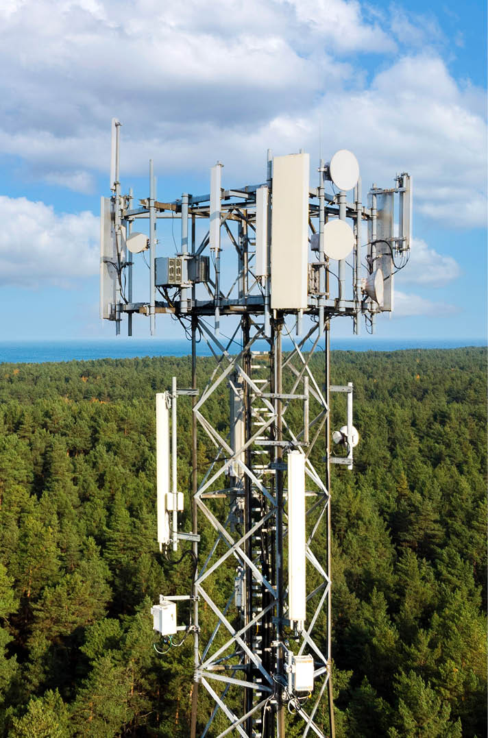telecommunication tower with antennas for 5g network on forest and blue sky background